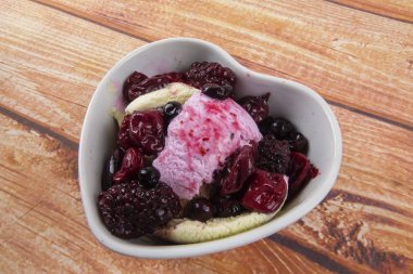 Yaban mersini, ahşap masa üzerinde chery ile dondurma kaşık toz.