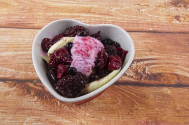 Yaban mersini, ahşap masa üzerinde chery ile dondurma kaşık toz.