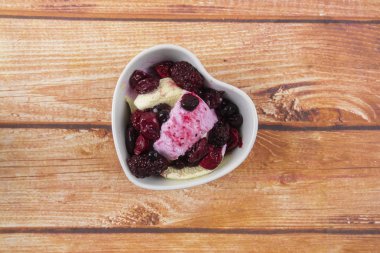 Yaban mersini, ahşap masa üzerinde chery ile dondurma kaşık toz.