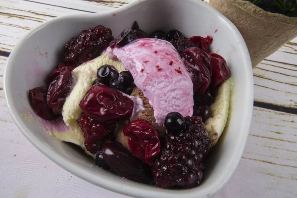 Yaban mersini, ahşap masa üzerinde chery ile dondurma kaşık toz.