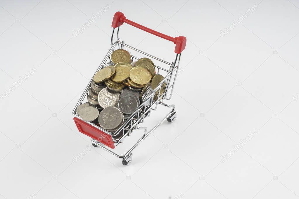 Trolley and coins isolated on white. Sales concept