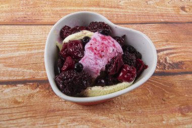 Yaban mersini, ahşap masa üzerinde chery ile dondurma kaşık toz.