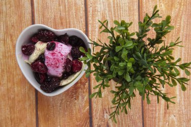 Yaban mersini, ahşap masa üzerinde chery ile dondurma kaşık toz.