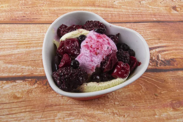 Yaban mersini, ahşap masa üzerinde chery ile dondurma kaşık toz.