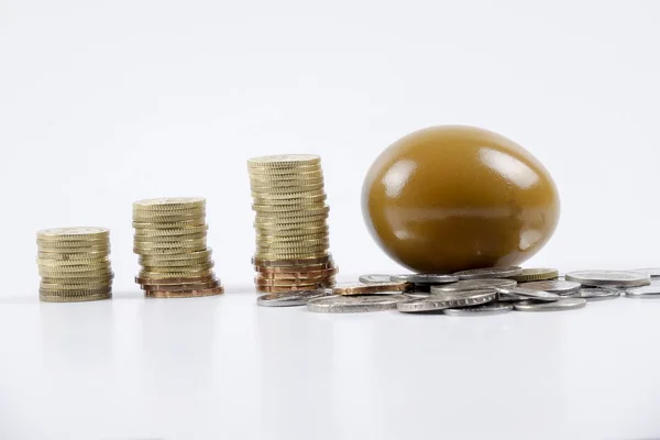 Guldägget och stack av mynt. Affärsverksamhet och investeringar koncept. — Stockfoto