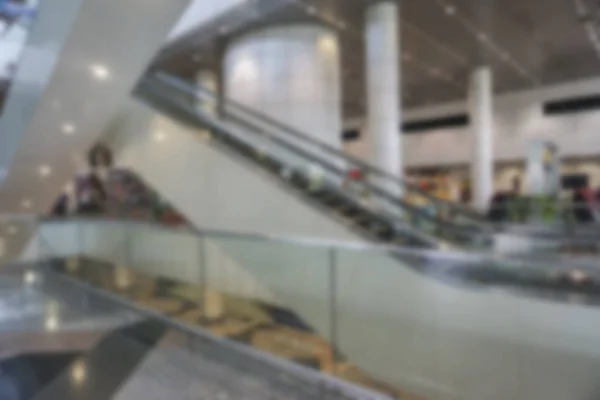 Pessoas no aeroporto terminal borrão fundo com luz bokeh . — Fotografia de Stock