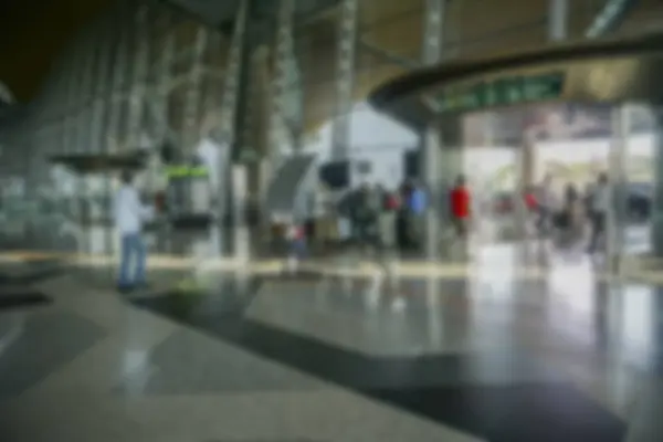 Pessoas no aeroporto terminal borrão fundo com luz bokeh . — Fotografia de Stock