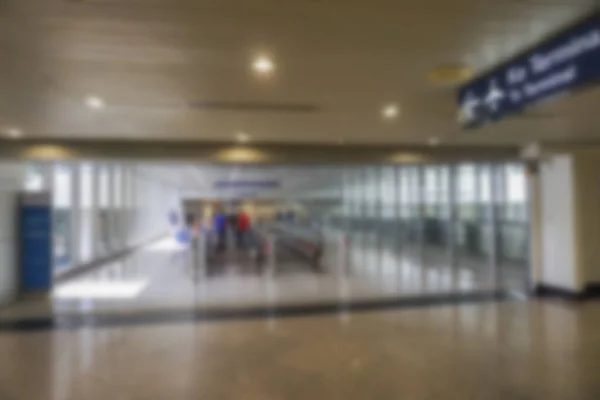 Mensen op de luchthaven terminal wazig achtergrond met bokeh licht. — Stockfoto