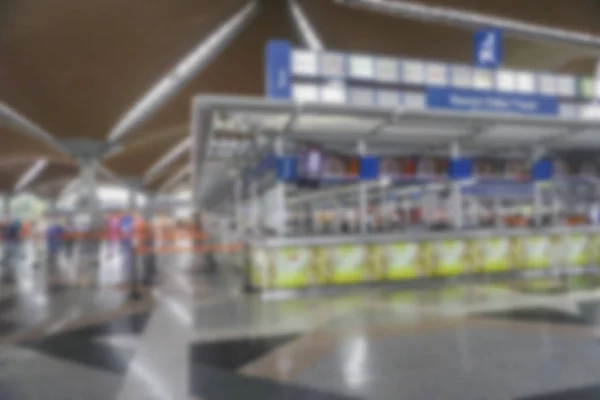 People at airport terminal blur background with bokeh light.