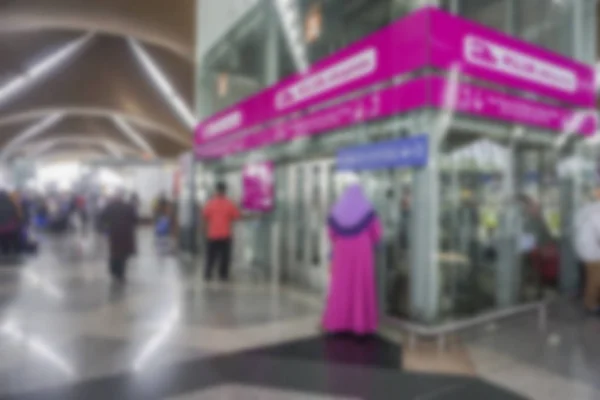 Pessoas no aeroporto terminal borrão fundo com luz bokeh . — Fotografia de Stock