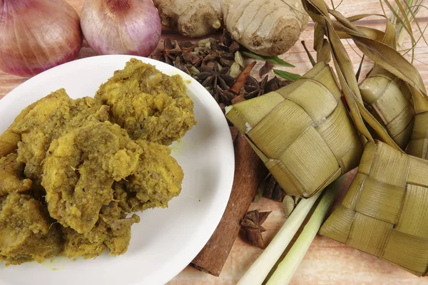 Prato malaio Rendang Ayam ou frango curry seco e Ketupat Nasi (Arroz Dumpling) sobre fundo de madeira — Fotografia de Stock