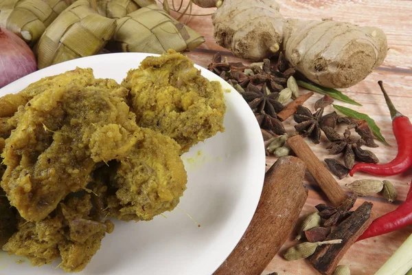 马来西亚菜巴东 Ayam 或干咖喱鸡和 Ketupat 鼻翼 （汤圆） 在木制的背景 — 图库照片