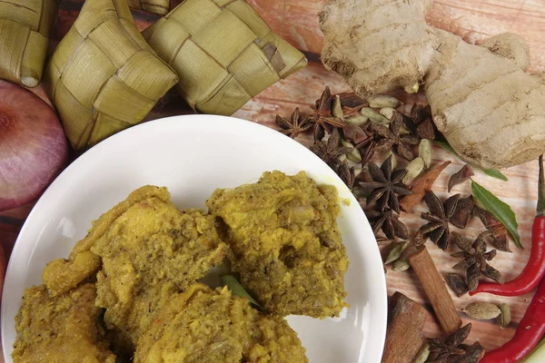 马来西亚菜巴东 Ayam 或干咖喱鸡和 Ketupat 鼻翼 （汤圆） 在木制的背景 — 图库照片