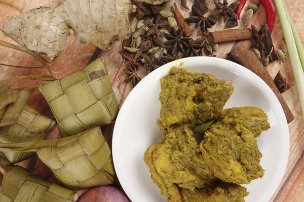 Prato malaio Rendang Ayam ou frango curry seco e Ketupat Nasi (Arroz Dumpling) sobre fundo de madeira — Fotografia de Stock