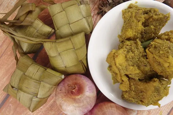 Malezya çanak Rendang Ayam veya kuru köri tavuk ve ahşap arka plan üzerinde Ketupat Nasi (pirinç hamur tatlısı) — Stok fotoğraf