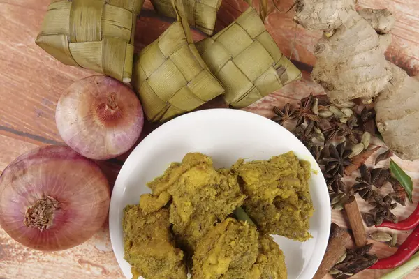 Prato malaio Rendang Ayam ou frango curry seco e Ketupat Nasi (Arroz Dumpling) sobre fundo de madeira — Fotografia de Stock