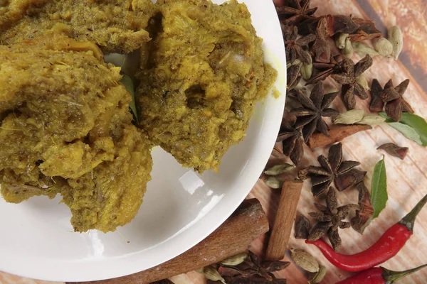 Malaysiska maträtt Rendang Ayam eller torr curry kyckling och Ketupat Nasi (ris klimp) över trä bakgrund — Stockfoto