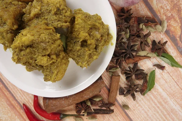 Malaysian dish Rendang Ayam or dry curry chicken and Ketupat Nasi (Rice Dumpling) over wooden background — Stock Photo, Image