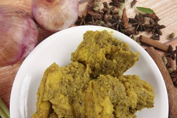 Malaysisches Gericht Rendang Ayam oder trockenes Curryhuhn und Ketupat Nasi (Reisknödel) über Holzgrund — Stockfoto