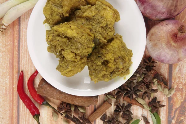 马来西亚菜巴东 Ayam 或干咖喱鸡和 Ketupat 鼻翼 （汤圆） 在木制的背景 — 图库照片