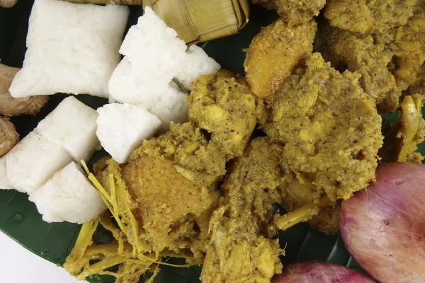 Malezya çanak Rendang Ayam veya kuru köri tavuk ve ahşap arka plan üzerinde Ketupat Nasi (pirinç hamur tatlısı) — Stok fotoğraf