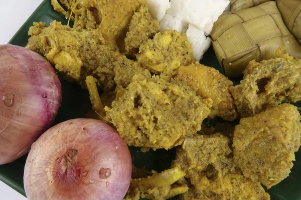 Plato malayo Rendang Ayam o pollo al curry seco y Ketupat Nasi (Rice Dumpling) sobre fondo de madera — Foto de Stock