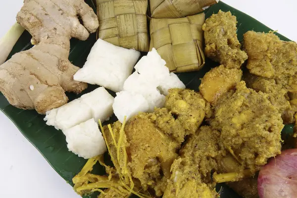 马来西亚菜巴东 Ayam 或干咖喱鸡和 Ketupat 鼻翼 （汤圆） 在木制的背景 — 图库照片