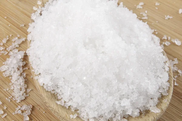 Nahaufnahme von Salz auf Holzlöffel über Holzgrund. — Stockfoto