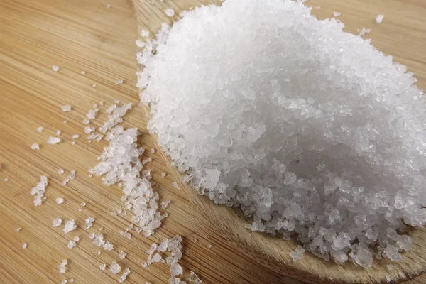 Primer plano de sal sobre cuchara de madera sobre fondo de madera . — Foto de Stock