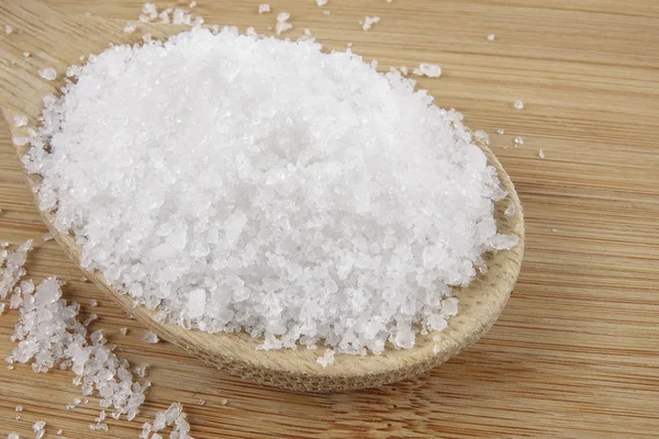 Nahaufnahme von Salz auf Holzlöffel über Holzgrund. — Stockfoto
