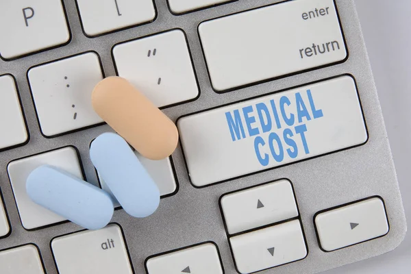 Медичні таблетки на клавіатурі з текстом MEDICAL COST. Медичний кооператив — стокове фото