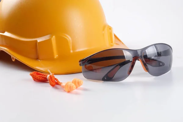 Yellow hardhat safety helmet,safety glass and ear plug isolated on white background. Industrial safety and health conceptual.