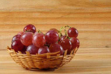 Sepet ormanlık arka plan üzerinde kırmızı üzüm.