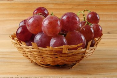 Sepet ormanlık arka plan üzerinde kırmızı üzüm.