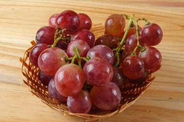 Sepet ormanlık arka plan üzerinde kırmızı üzüm.