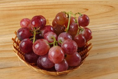 Sepet ormanlık arka plan üzerinde kırmızı üzüm.