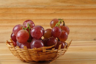 Sepet ormanlık arka plan üzerinde kırmızı üzüm.