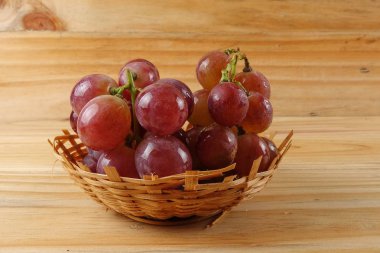 Sepet ormanlık arka plan üzerinde kırmızı üzüm.