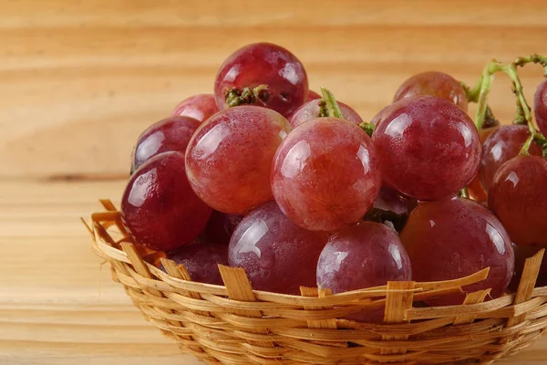 Sepet ormanlık arka plan üzerinde kırmızı üzüm.