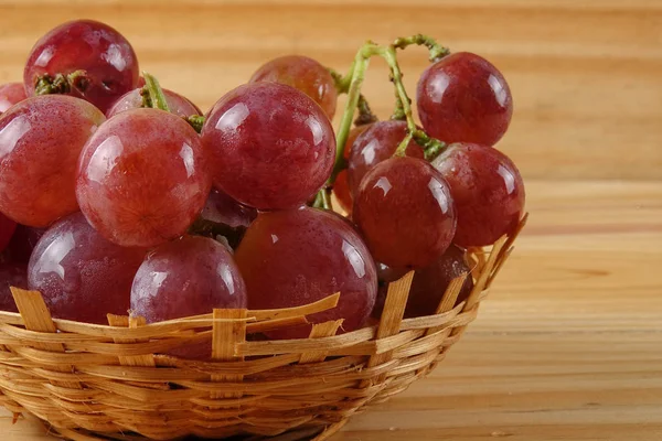 Rote Trauben auf dem Korb vor bewaldetem Hintergrund. — Stockfoto