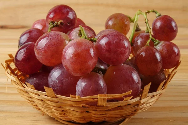 Sepet ormanlık arka plan üzerinde kırmızı üzüm.