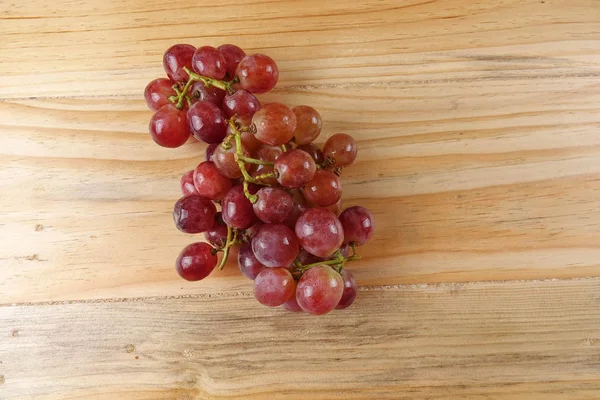 Red grape on the basket over wooded background. — Stock Photo, Image