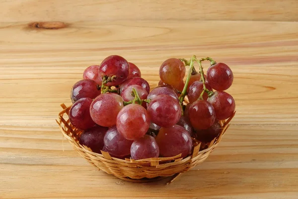 Sepet ormanlık arka plan üzerinde kırmızı üzüm.