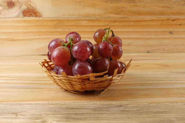 Rote Trauben auf dem Korb vor bewaldetem Hintergrund. — Stockfoto