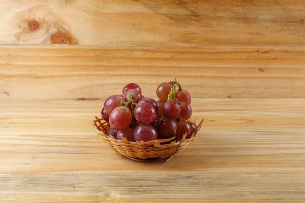 Rote Trauben auf dem Korb vor bewaldetem Hintergrund. — Stockfoto