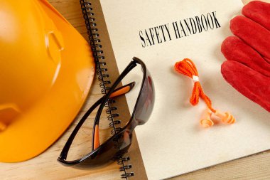 Emanet şapka, eldiven, gözlük, kulak tıkacı ve not defteri. Sağlığı ve güvenliği kavramı.