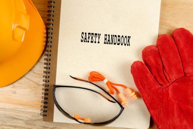 Emanet şapka, eldiven, gözlük, kulak tıkacı ve not defteri. Sağlığı ve güvenliği kavramı.