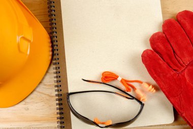 Emanet şapka, eldiven, gözlük, kulak tıkacı ve not defteri. Sağlığı ve güvenliği kavramı.