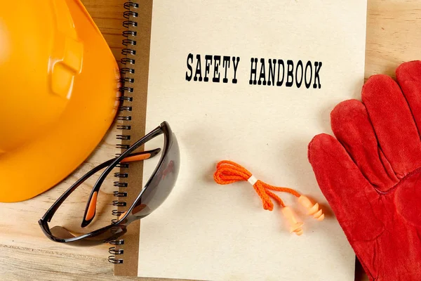 Cappello di sicurezza, guanto, occhiali, tappi per le orecchie e taccuino. Concetto di salute e sicurezza . — Foto Stock