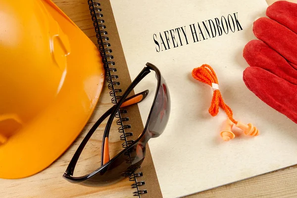 Emanet şapka, eldiven, gözlük, kulak tıkacı ve not defteri. Sağlığı ve güvenliği kavramı.